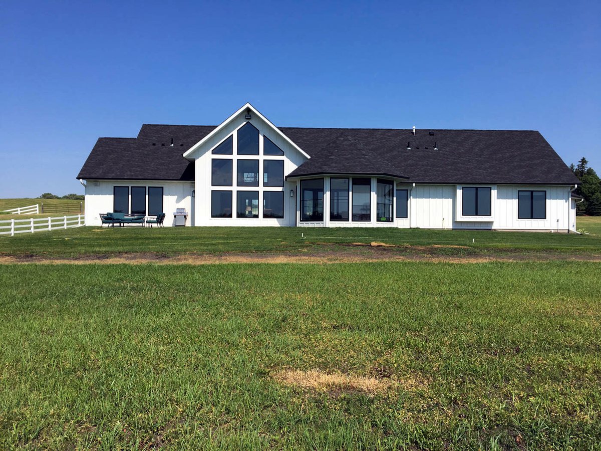 Modern farmhouse custom home with green lawn